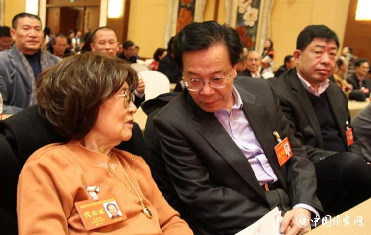 文潔若、李福明等代表在報告會前交談。