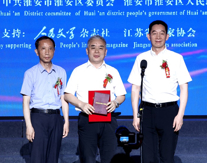 中國作家協會黨組成員、書記處書記、《人民文學》雜志社主編施戰軍，淮安市人大常委會副主任范更生為王躍文頒獎