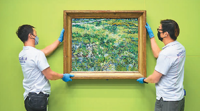 　香港故宮文化博物館與英國國家美術館團隊共同檢查及安裝梵高名畫《蝴蝶與長草地》。 　　香港故宮文化博物館供圖