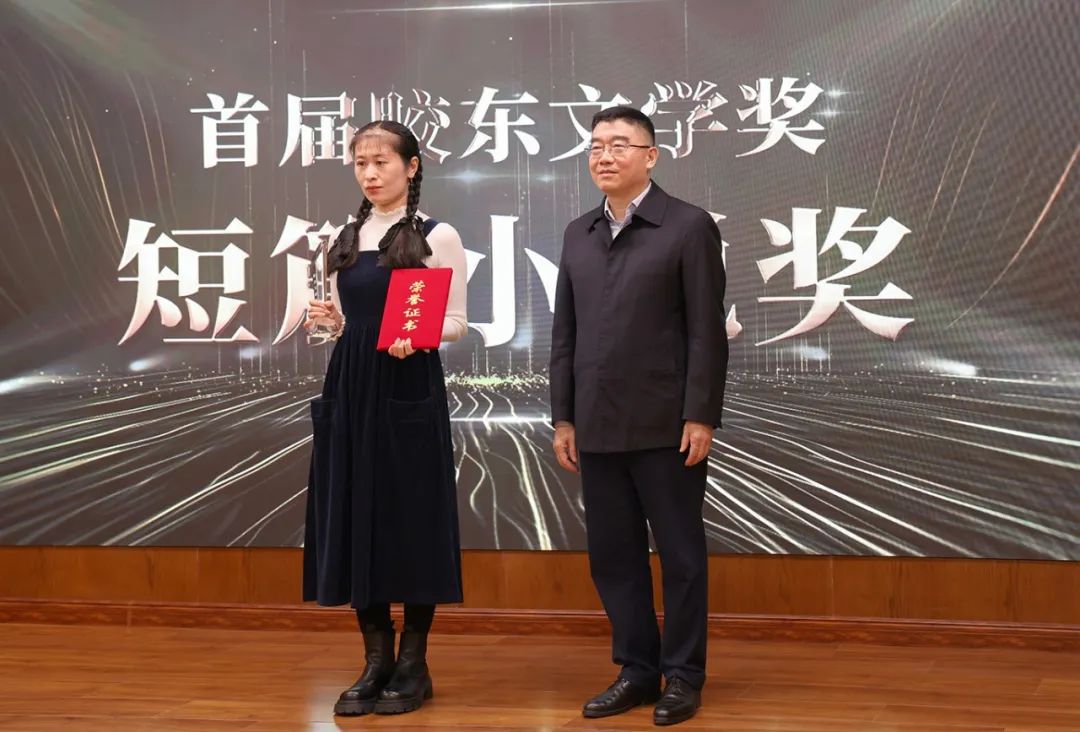 山東省作協黨組書記、副主席趙藝?。ㄓ乙唬? 為短篇小說獎獲得者王銘嬋頒獎