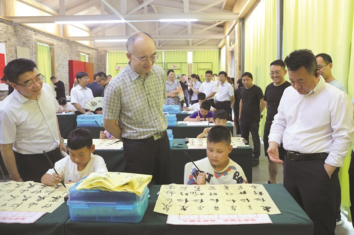 在山東舉辦的“做人民的學生——中國作協作家活動周”期間，作家們在濟寧考察調研公益書法課堂。