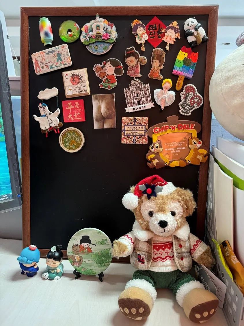 辦公桌一角的冰箱貼小黑板，是朋友和自己從各地帶回來的愛與新知