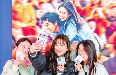 2月18日，觀眾在貴州省黔西市一家影院的電影海報前留影。 新華社發