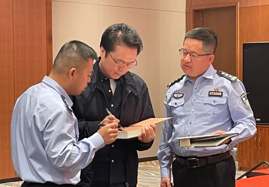 活動期間，陳彥（圖中）在給警營作家簽名。