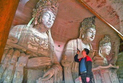 義務文保員在對重慶市大足區寶頂鎮香山社區的佛祖巖摩崖造像進行巡查。新華社記者 王全超攝