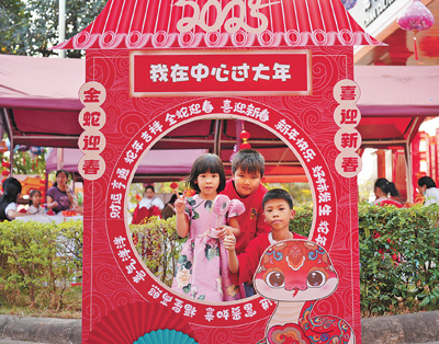 老撾民眾在“歡樂春節”廟會現場設立的新春祈福打卡點拍照。  坎帕頌攝