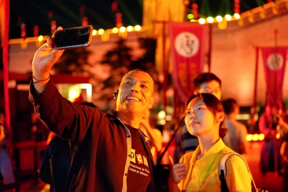 參加2025國際青春詩會的拉美詩人和中國詩人在西安永寧門觀看歡迎儀式。圖為墨西哥詩人馬努艾爾·夸烏特勒在歡迎儀式后與志愿者合影